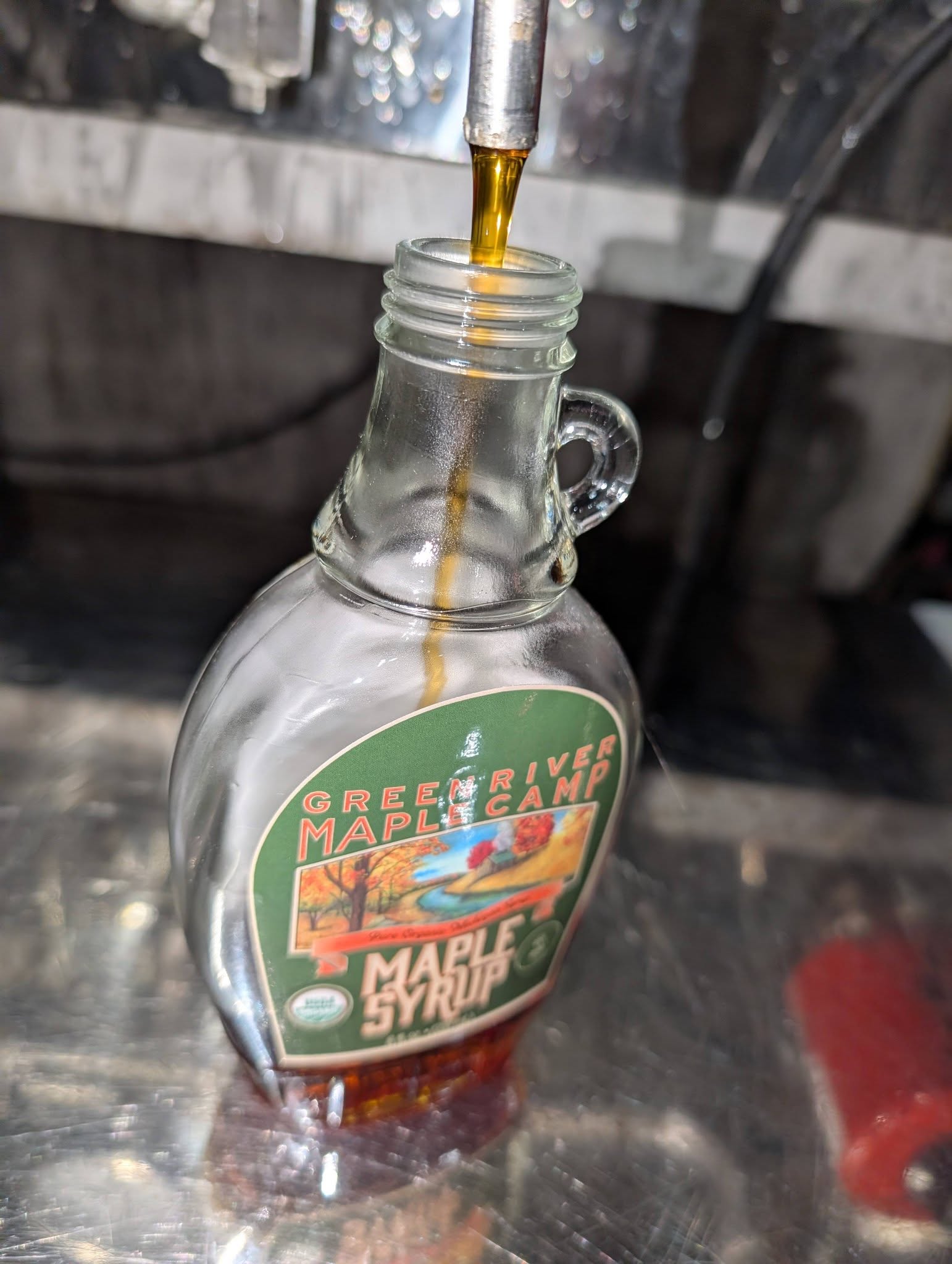 Golden maple syrup streaming into a Green River glass jug