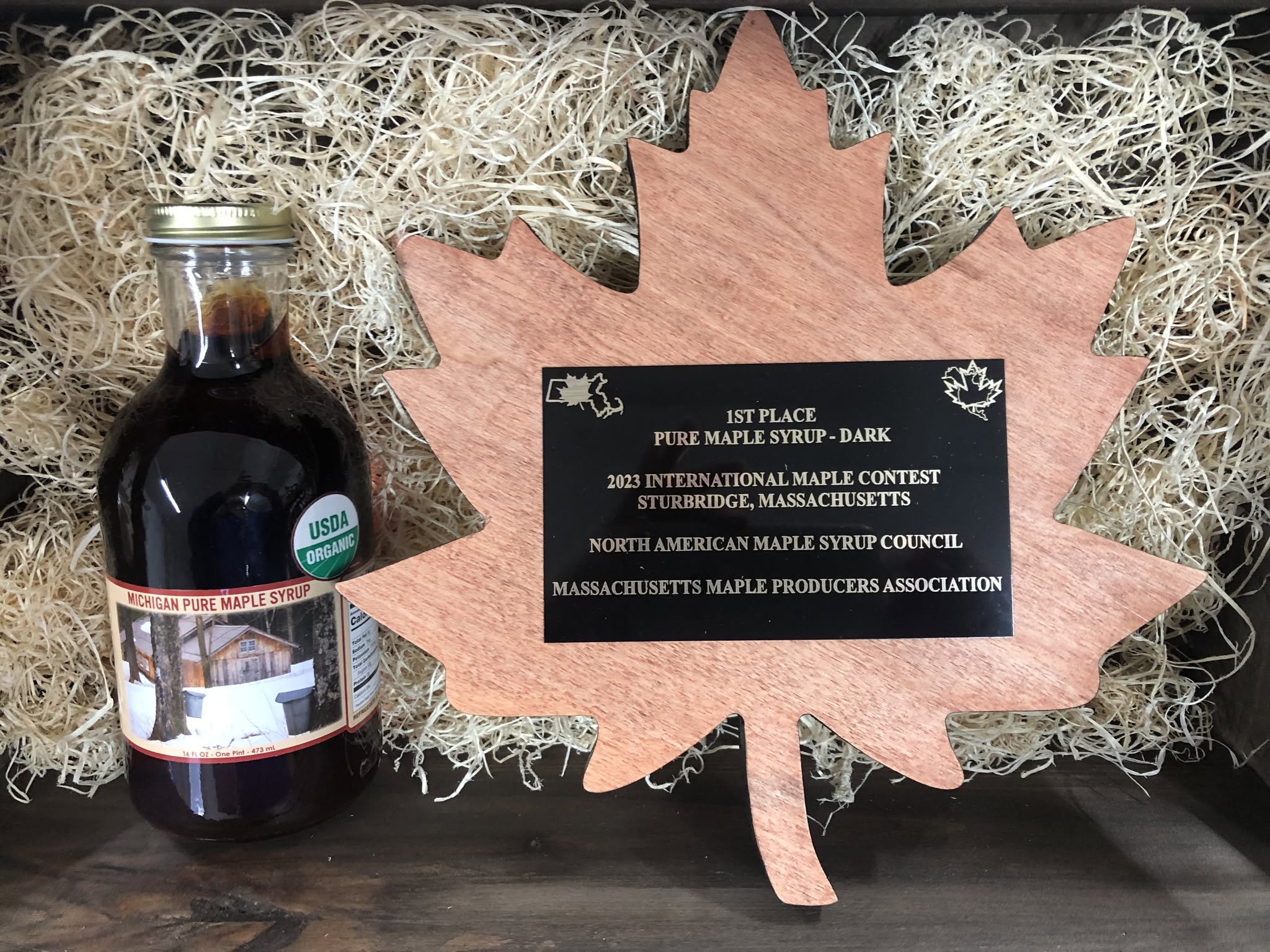 First-place plaque for Dark maple syrup from the North American Maple Syrup Council's 2023 contest in Sturbridge, Massachusetts, beside a pint of Green River syrup