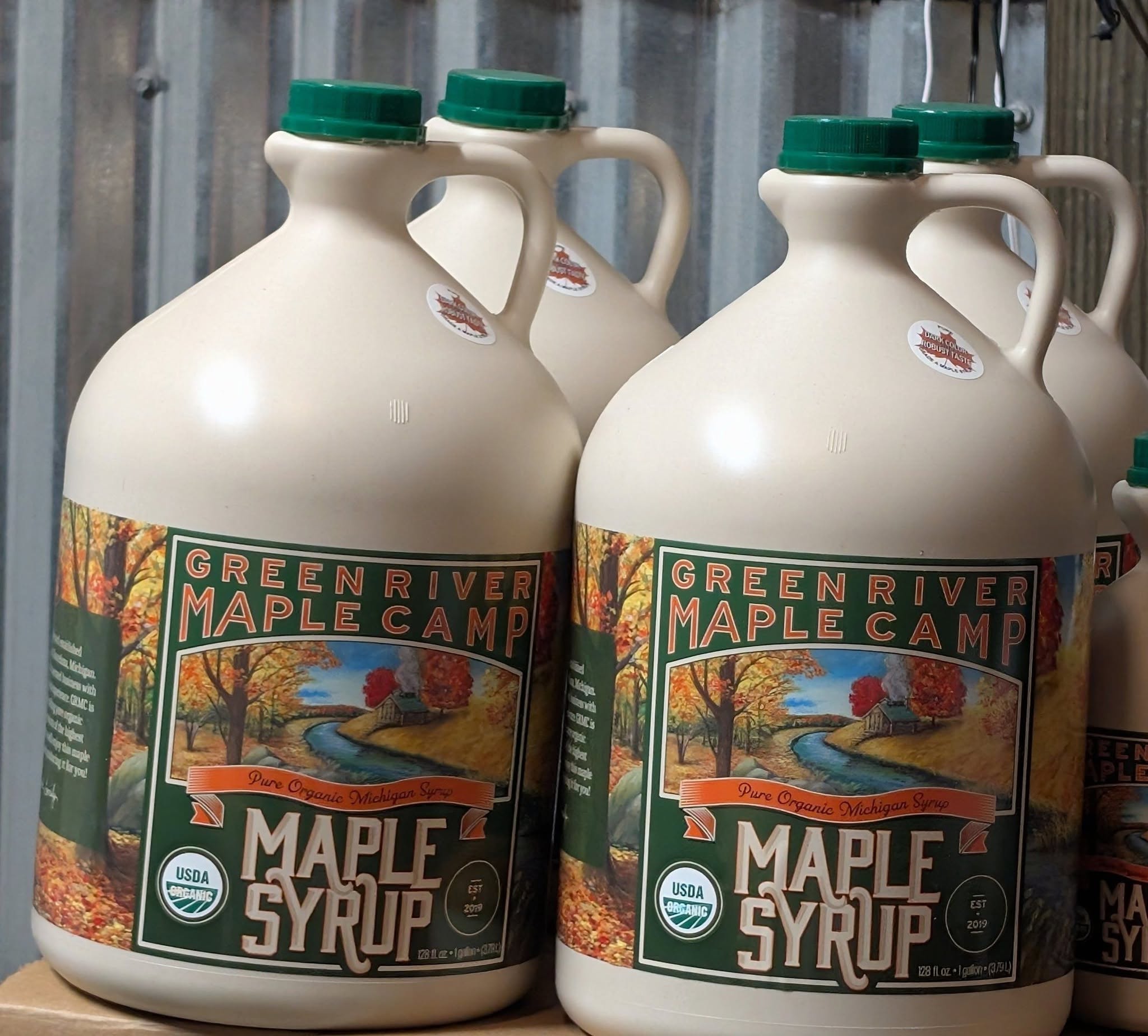 Gallon jugs of Green River Maple Camp syrup with Dark/Robust stickers